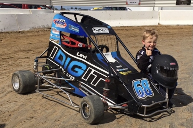 child next to a go kart