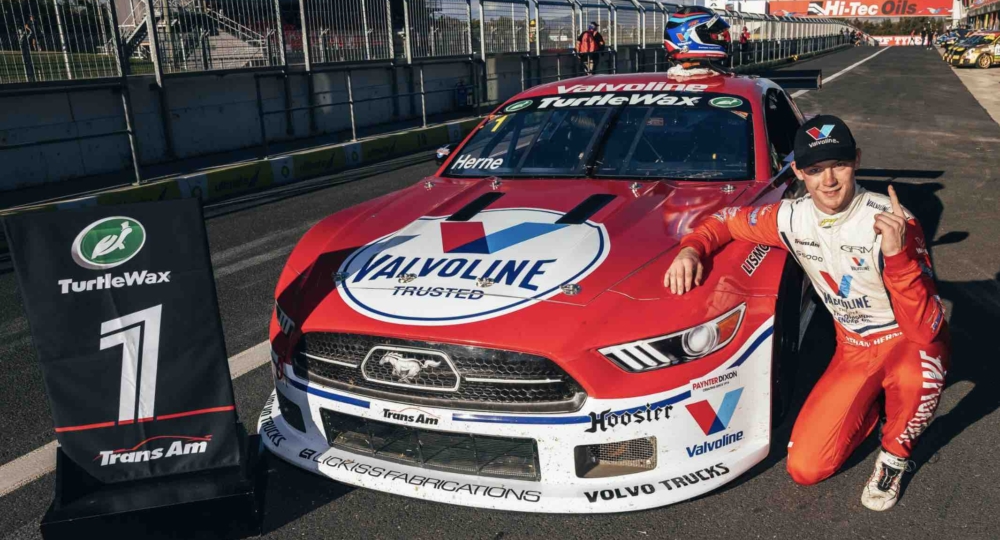 nathan herne next to a race caar